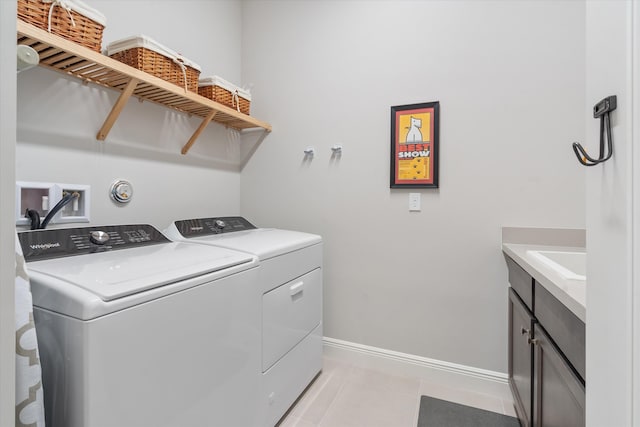 laundry room featuring separate washer and dryer, light tile patterned floors, sink, and cabinets