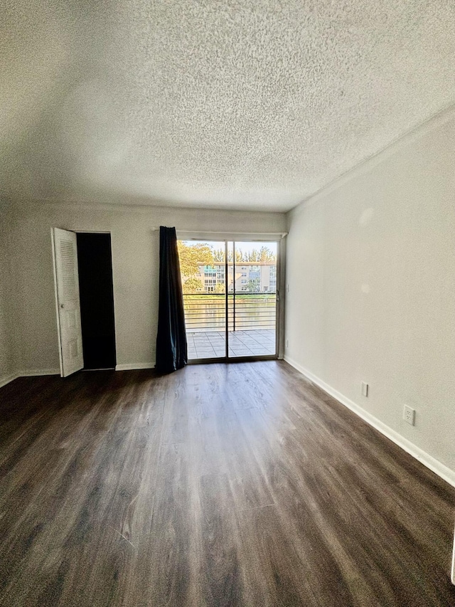 spare room featuring dark hardwood / wood-style flooring and a textured ceiling