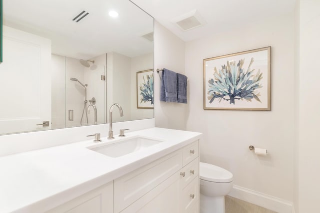 bathroom with vanity, a shower with door, and toilet