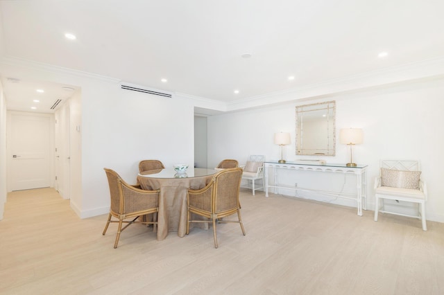 dining area with ornamental molding and light wood-type flooring