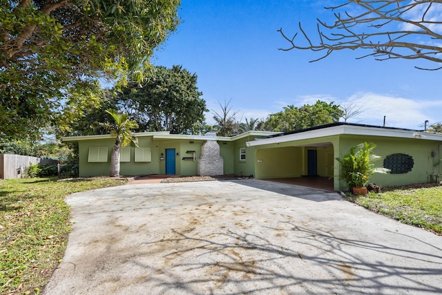 mid-century inspired home with driveway and stucco siding