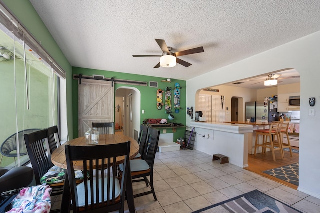 dining room with a ceiling fan, arched walkways, visible vents, and light tile patterned floors