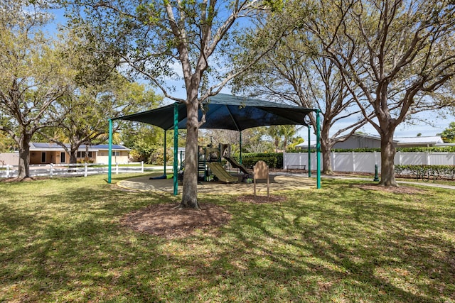 view of yard featuring playground community and fence