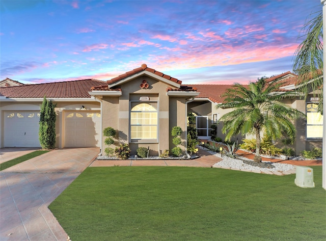 mediterranean / spanish-style home with a garage and a yard