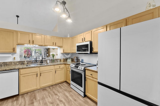 kitchen featuring decorative light fixtures, sink, dark stone countertops, light brown cabinets, and white appliances