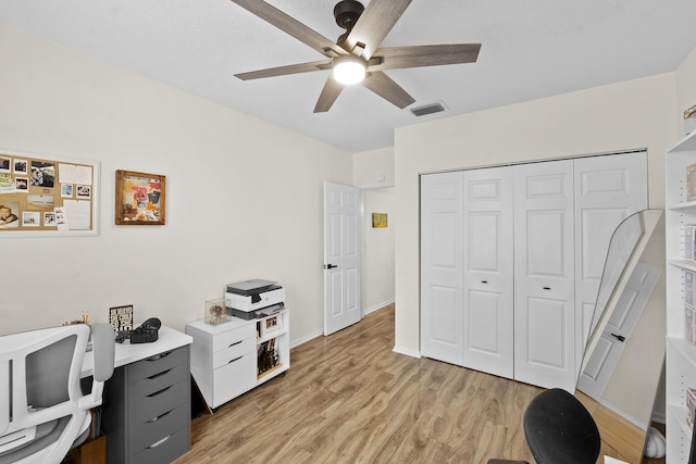 home office with light hardwood / wood-style flooring and ceiling fan