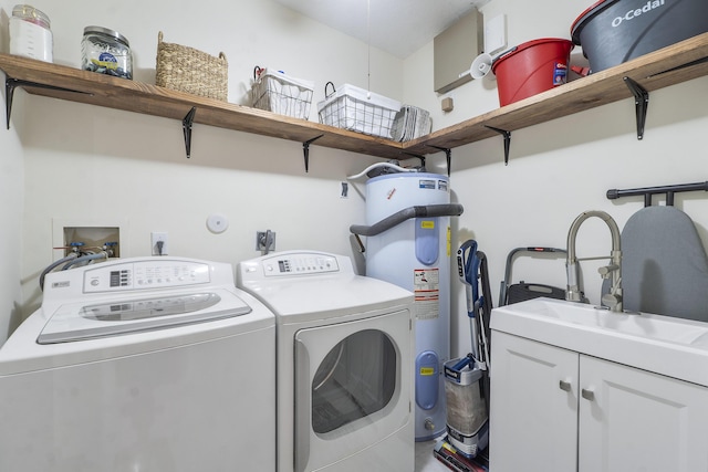 washroom featuring cabinets, washing machine and dryer, electric water heater, and sink