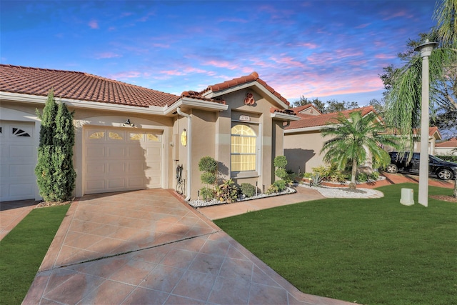 mediterranean / spanish-style home featuring a garage and a yard