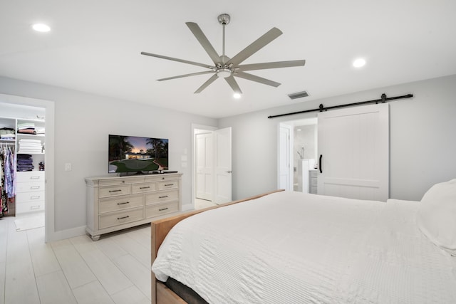 bedroom featuring recessed lighting, visible vents, a spacious closet, and a barn door