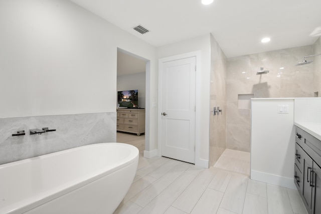 full bath with recessed lighting, vanity, visible vents, a freestanding bath, and walk in shower