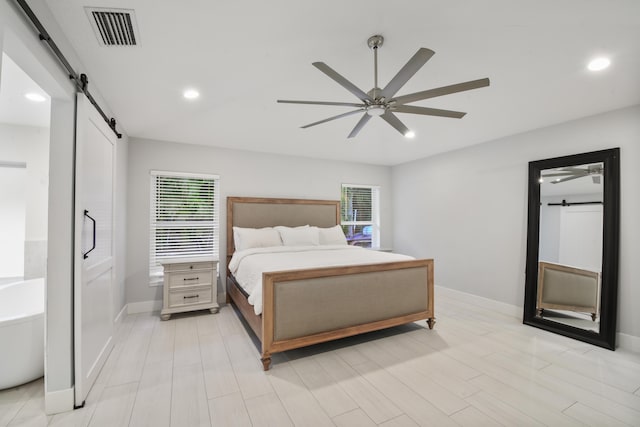 bedroom with ceiling fan, a barn door, recessed lighting, visible vents, and baseboards