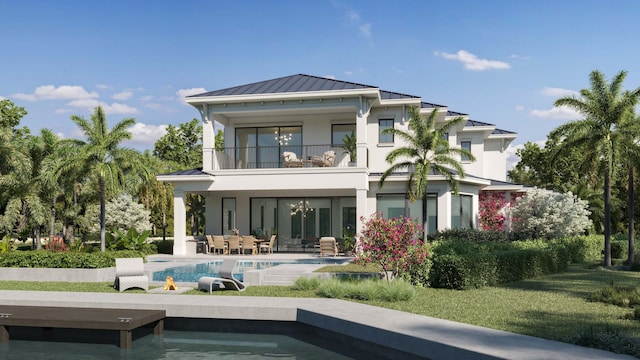 rear view of house with a balcony, metal roof, a standing seam roof, a patio area, and stucco siding