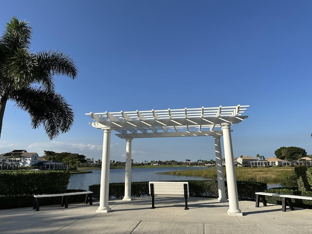 view of community with a pergola and a water view