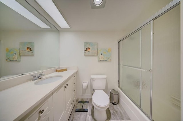 bathroom featuring an enclosed shower, vanity, wood-type flooring, and toilet