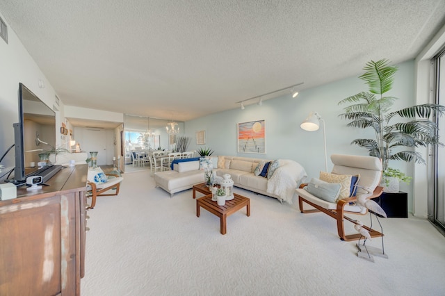 carpeted living room featuring rail lighting and a textured ceiling