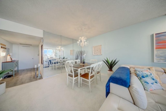 dining room with a textured ceiling, wood-type flooring, and a chandelier