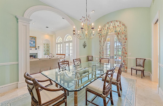 dining room featuring french doors, lofted ceiling, an inviting chandelier, and built in features