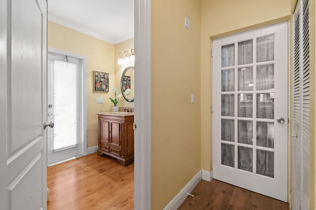 doorway to outside with ornamental molding and hardwood / wood-style floors