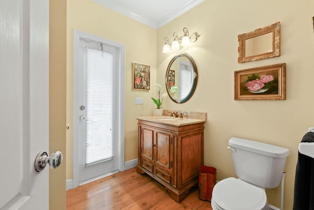 bathroom with hardwood / wood-style flooring, vanity, crown molding, and toilet