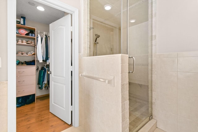 bathroom featuring wood-type flooring and an enclosed shower