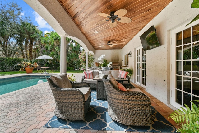 view of patio with an outdoor kitchen, a fenced in pool, ceiling fan, and an outdoor hangout area