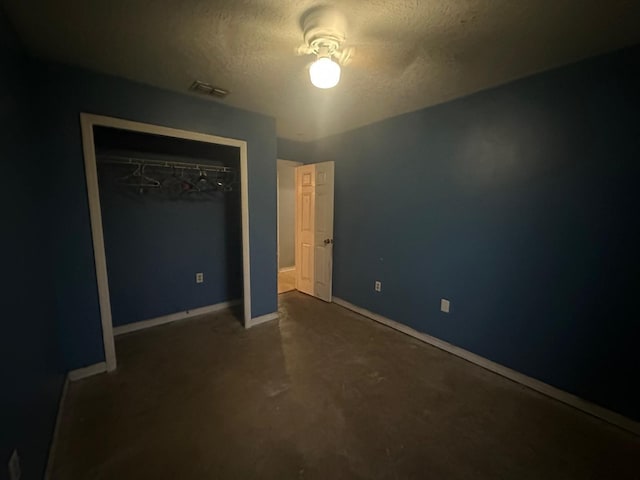 unfurnished bedroom featuring a textured ceiling and a closet