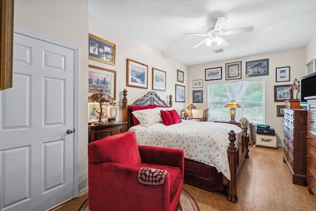 bedroom with light wood-style flooring, baseboards, and a ceiling fan