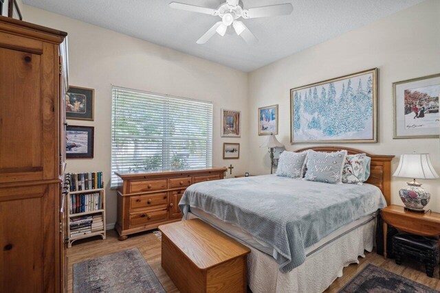 bedroom with a ceiling fan and light wood-style floors