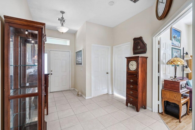 entrance foyer with light tile patterned floors and baseboards