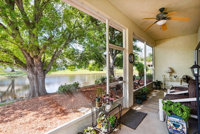 sunroom featuring a water view and ceiling fan