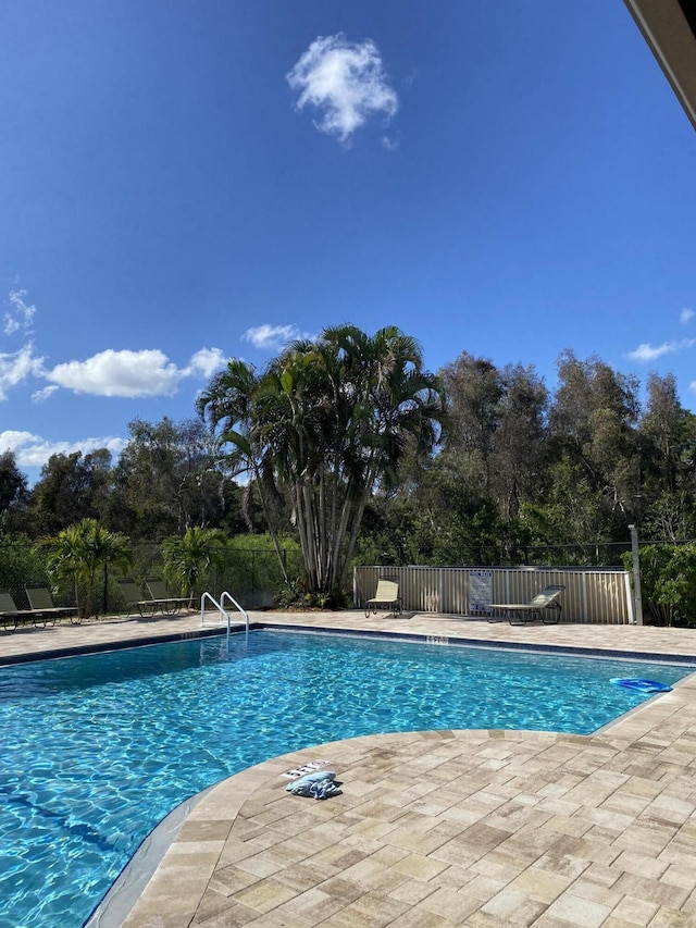 community pool featuring a patio area and fence