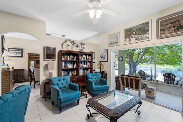 living area featuring ceiling fan, arched walkways, light tile patterned floors, and visible vents