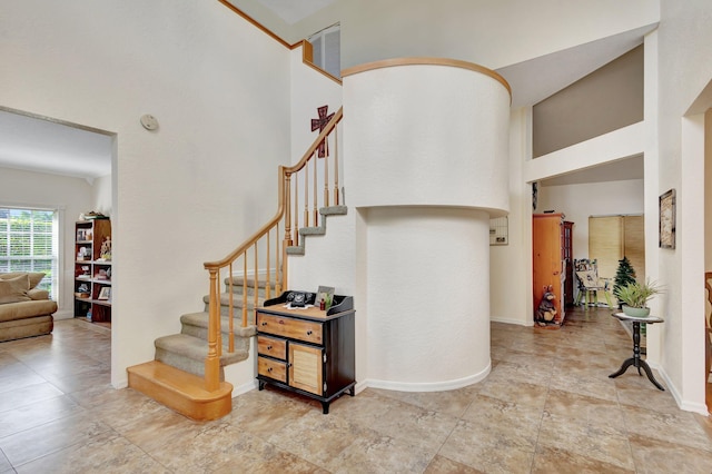 stairway featuring a towering ceiling