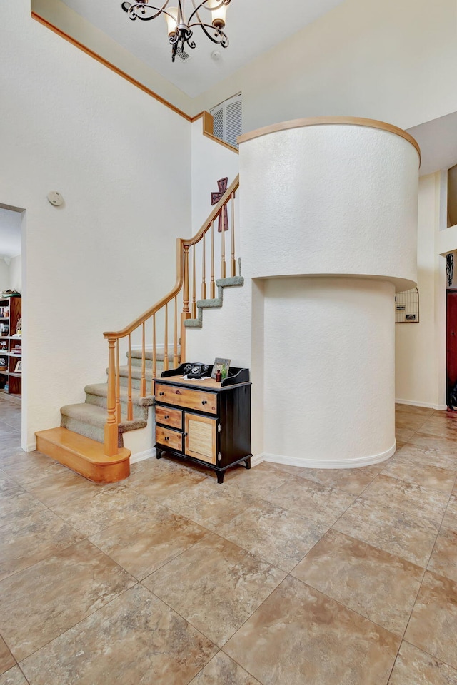 staircase with a chandelier and a high ceiling