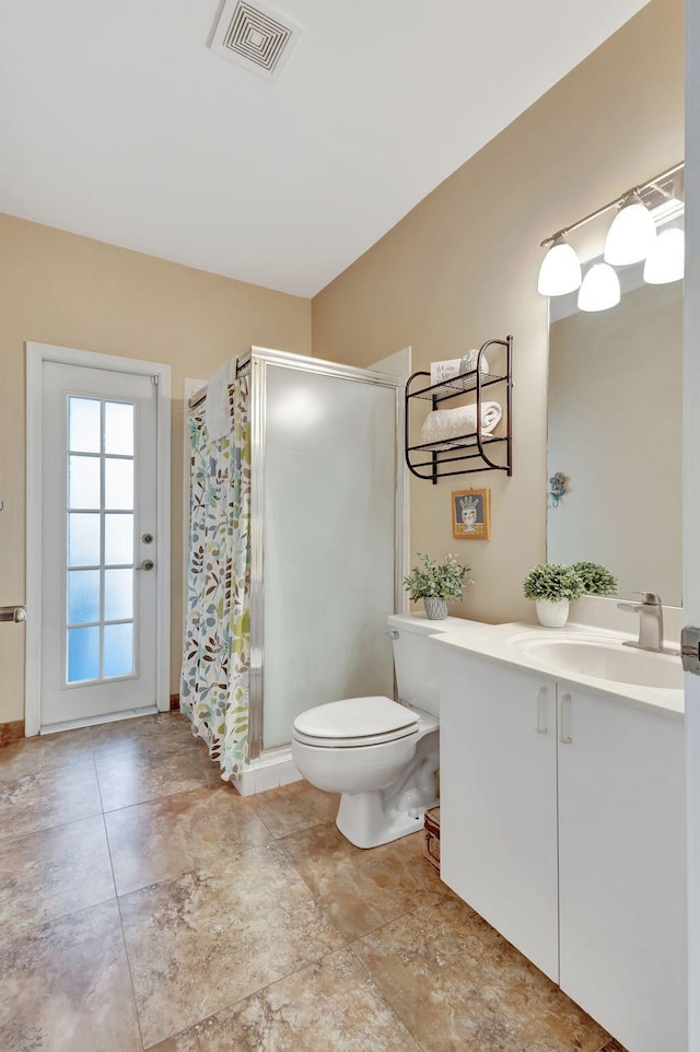 bathroom featuring vanity, a shower with door, and toilet