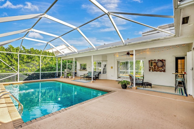 view of pool with a patio, ceiling fan, and glass enclosure