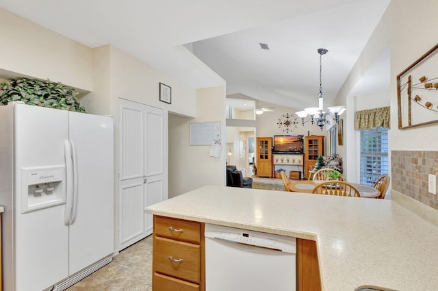 kitchen with vaulted ceiling, hanging light fixtures, light tile patterned floors, white appliances, and ceiling fan with notable chandelier