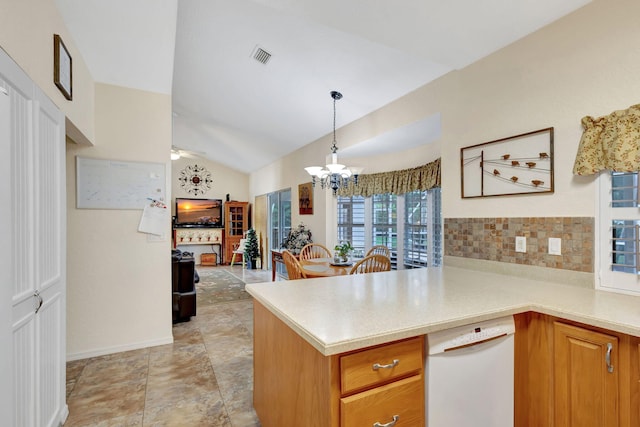 kitchen with lofted ceiling, kitchen peninsula, pendant lighting, ceiling fan with notable chandelier, and backsplash