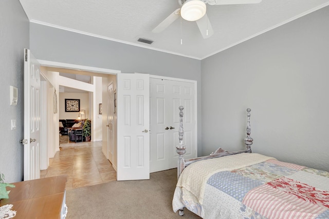 carpeted bedroom featuring crown molding, ceiling fan, and a closet