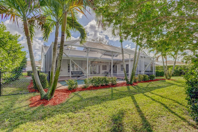 back of house featuring a lanai and a yard