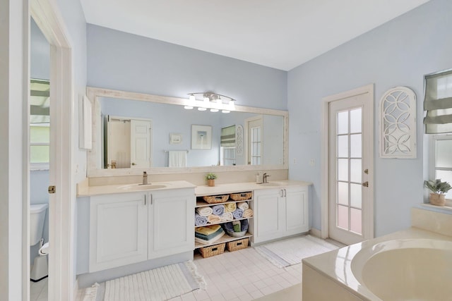 bathroom with vanity, a tub, tile patterned floors, and toilet