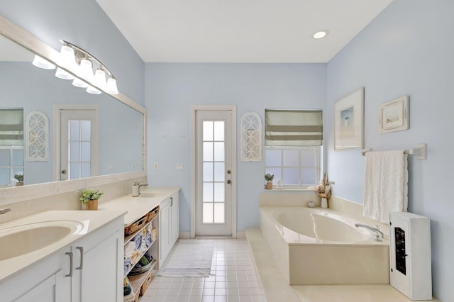 bathroom featuring tile patterned flooring, vanity, and a tub to relax in