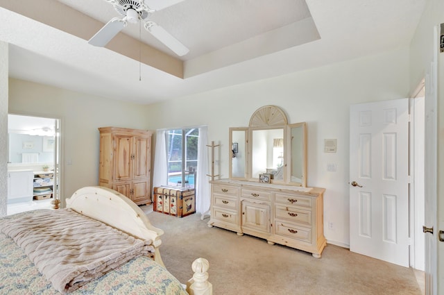 carpeted bedroom featuring a raised ceiling and ceiling fan