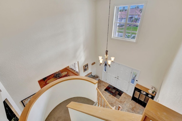 staircase with a notable chandelier