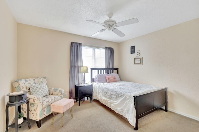 bedroom with light carpet, ceiling fan, and a textured ceiling