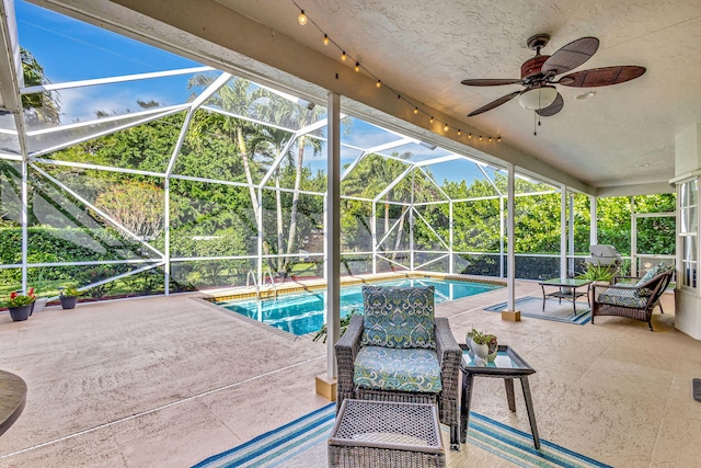 view of patio with ceiling fan and glass enclosure