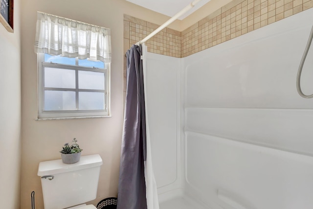 bathroom with curtained shower and toilet