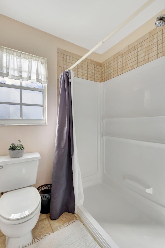 bathroom with curtained shower and toilet