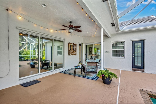 view of patio with ceiling fan and a lanai