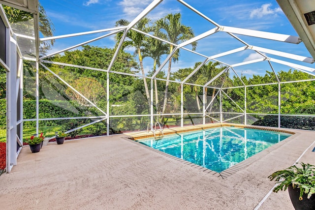 view of swimming pool with a patio area and glass enclosure